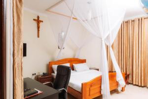a bedroom with a bed with a cross on the wall at Kampala Kolping Hotel in Kampala