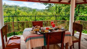 a table with a plate of food on a deck at Villa Serene Herbs Dickwella in Dickwella