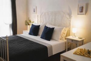 a bedroom with a white bed with blue pillows at TT Apartmani - Historic Center Pula in Pula
