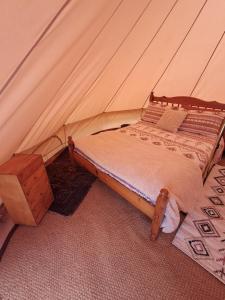 a bed in a tent with a wooden table at The Old Waterworks - Venus Bell Tent in Clare