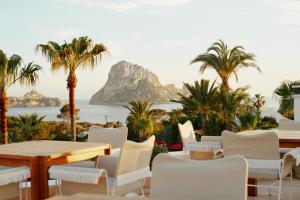 a table and chairs with a view of the ocean at Petunia Ibiza, a Beaumier hotel in Cala Vadella
