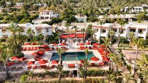 an aerial view of a resort with a pool and palm trees at Petunia Ibiza, a Beaumier hotel in Cala Vadella