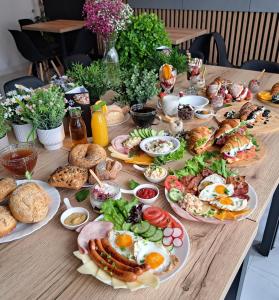 a table with plates of breakfast food on it at Tesao Room by Dworek Marino in Grzybowo