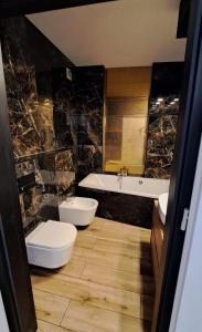 a bathroom with two toilets and a tub and a sink at Tesao Room by Dworek Marino in Grzybowo +20 photos