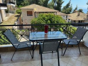 a glass table and chairs on a balcony at Danai Nefeli Apartment in Siviri