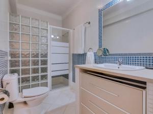 a bathroom with a toilet and a sink and a shower at Vale do Farol Cozy Retreat in Quarteira +27 photos