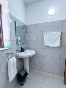 a white bathroom with a sink and a mirror at Vangert Apartment in Berat +15 photos