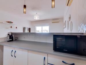 a kitchen with a counter top with a microwave at Vale do Farol Cozy Retreat in Quarteira