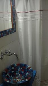 baño con lavabo de mosaico y cortina de ducha en Estudio en Edificio Alnes en Mar del Plata