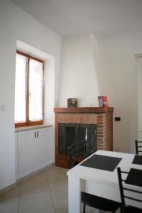 a living room with a fireplace and a table and chairs at Casa di Nonna Angela in Guadamello