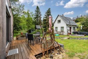 a wooden deck with a table and chairs on a house at Schmidtsches Quartier in Oybin
