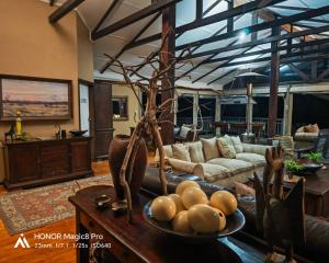 a living room with a bowl of fruit on a table at Thornwood in Hluhluwe