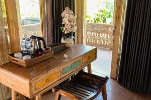 a wooden table with a tea kettle and flowers on it at Rise Simpangan Villa in Payangan