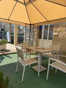 a wooden table and chairs under a large umbrella at House 23 A2 in Tivat