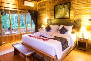 a bedroom with a large bed with flowers on it at Rise Simpangan Villa in Payangan