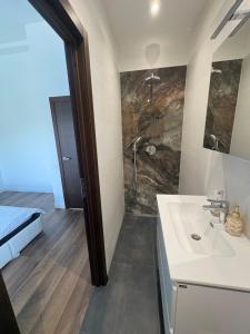 a bathroom with a sink and a shower at Jasmine Guest Room in Jauntīreļi
