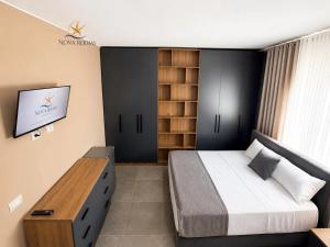 a bedroom with a bed and a tv on a wall at Nova Rooms Velipojë in Velipojë