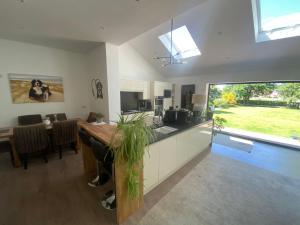 a kitchen and dining room with a table and a large window at The Dales in Marshside