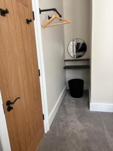 a hallway with a wooden door and a mirror at Strathmore Guest house in Fort William