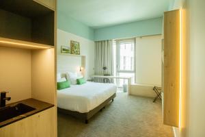 a hotel room with a bed and a window at Ysotop Hôtel Grenoble in Grenoble