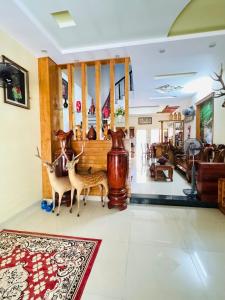 a living room with two deer statues on the floor at Nhà nghỉ B48 in Cù Lao Tâu