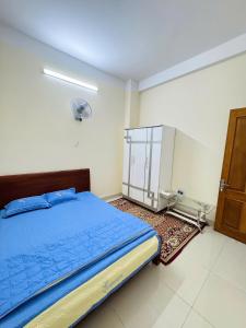 a bedroom with a blue bed and a closet at Nhà nghỉ B48 in Cù Lao Tâu