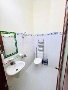 a white bathroom with a sink and a toilet at Nhà nghỉ B48 in Cù Lao Tâu