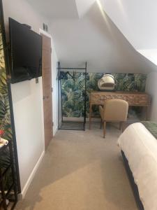 a bedroom with a bed and a desk with a television at Wendys house in Sarisbury Green