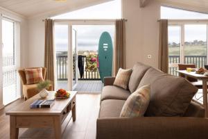 a living room with a couch and a surfboard at Lost Shore Surf Resort in Ratho