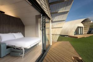 a bed on the balcony of a house at Lost Shore Surf Resort in Ratho