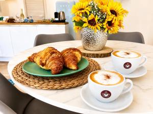 a table with croissants and two cups of coffee at 2 Steps by the Como Lake in Mandello del Lario +9 photos