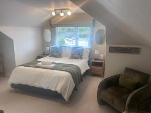 a bedroom with a bed and a chair and a window at Wendys house in Sarisbury Green
