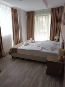 a bedroom with a large bed in front of windows at Sea View Apartments Olimp by Stela in Olimp +23 photos
