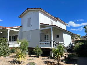 a white house with a lot of plants at Résidence Lagrange Vacances La Grenadine in Marseillan