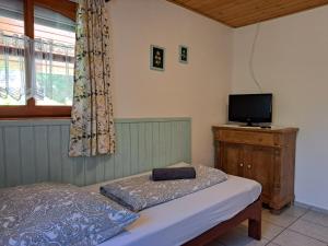 a bedroom with a bed and a flat screen tv at Diófa Vendégházak in Tiszafüred