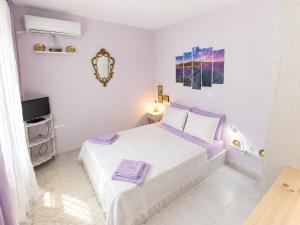 a white bedroom with a bed and a tv at Marilia GuestHouse - Seaside Retreat in Evia in Agia Anna