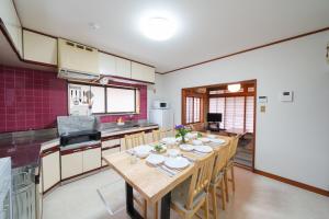 a kitchen with a wooden table with chairs in it at 民泊ａｉｋｏ in Fukushima