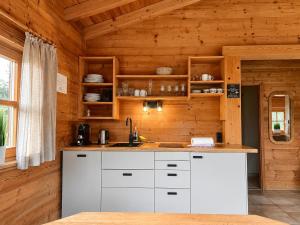 a kitchen with white cabinets in a wooden cabin at Chalets mit Schlierseeblick, neue Küche neues Bad in Schliersee
