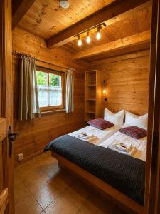 a bedroom with a bed in a wooden cabin at Chalets mit Schlierseeblick, neue Küche neues Bad in Schliersee