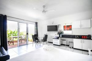 a kitchen with white cabinets and a table with chairs at DHR U120 - The Oceana in Eimeo