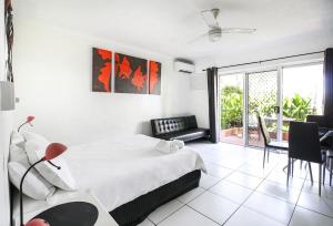 a white bedroom with a bed and a dining room at DHR U120 - The Oceana in Eimeo