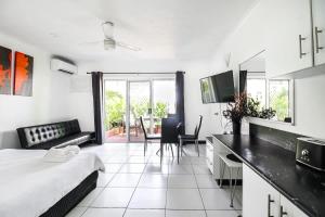a bedroom with a bed and a kitchen with a table at DHR U120 - The Oceana in Eimeo