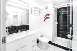 a white bathroom with a toilet and a shower at DHR U120 - The Oceana in Eimeo