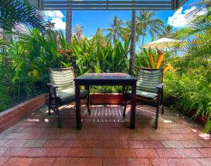 a table with two chairs and an umbrella on a patio at DHR U120 - The Oceana in Eimeo +5 photos