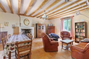 a living room with a table and chairs and a fireplace at Le Vallon in Mondion