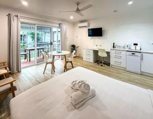 a bedroom with a bed and a kitchen with a table at U222 - The Serenity in Eimeo