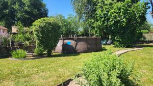 a backyard with a dog house in the grass at L'étoile du matin in Terville