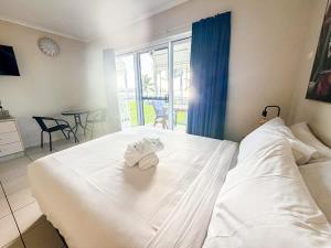 a bedroom with a white bed with towels on it at U240 Dhr in Eimeo