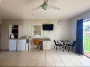 a kitchen with a table and a table and chairs at U240 Dhr in Eimeo