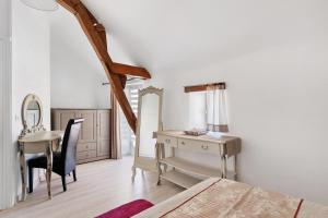 a bedroom with a desk and a dressing table at Le Vallon in Mondion